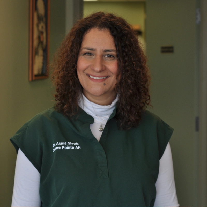 Asma Ghrab with curly dark hair smiles at the camera.