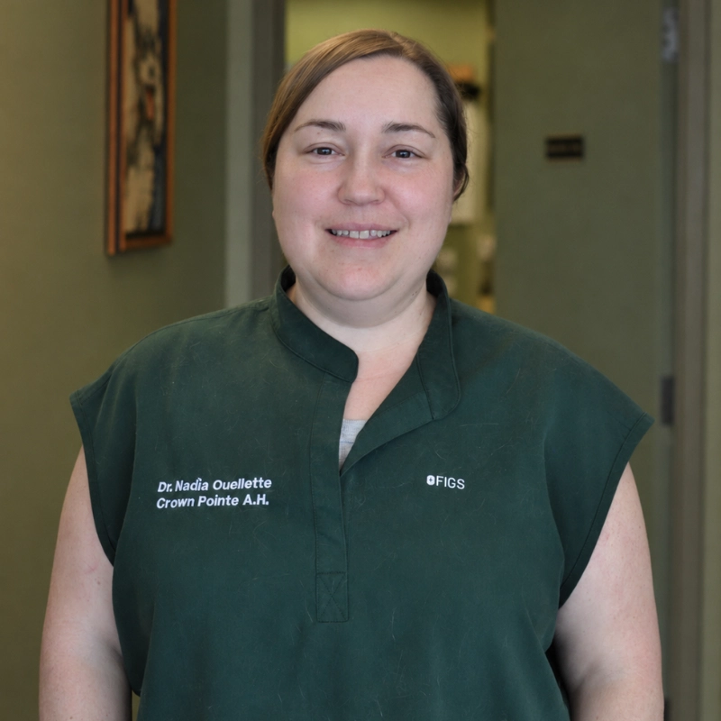 Dr. Nadia Ouellette, Crown Pointe A.H., wearing a dark green scrub top with the FIGS logo on the right chest.